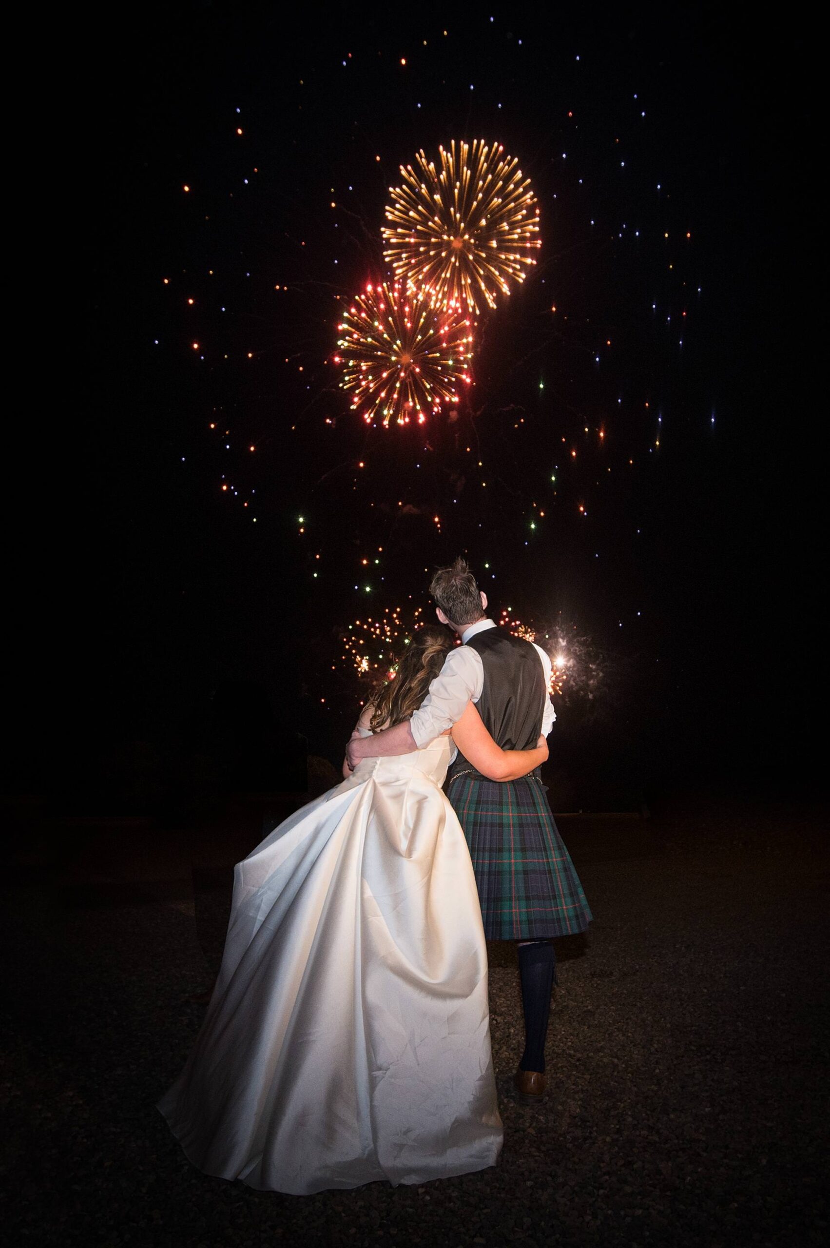Back of couple as they look at fireworks at Hopetoun House