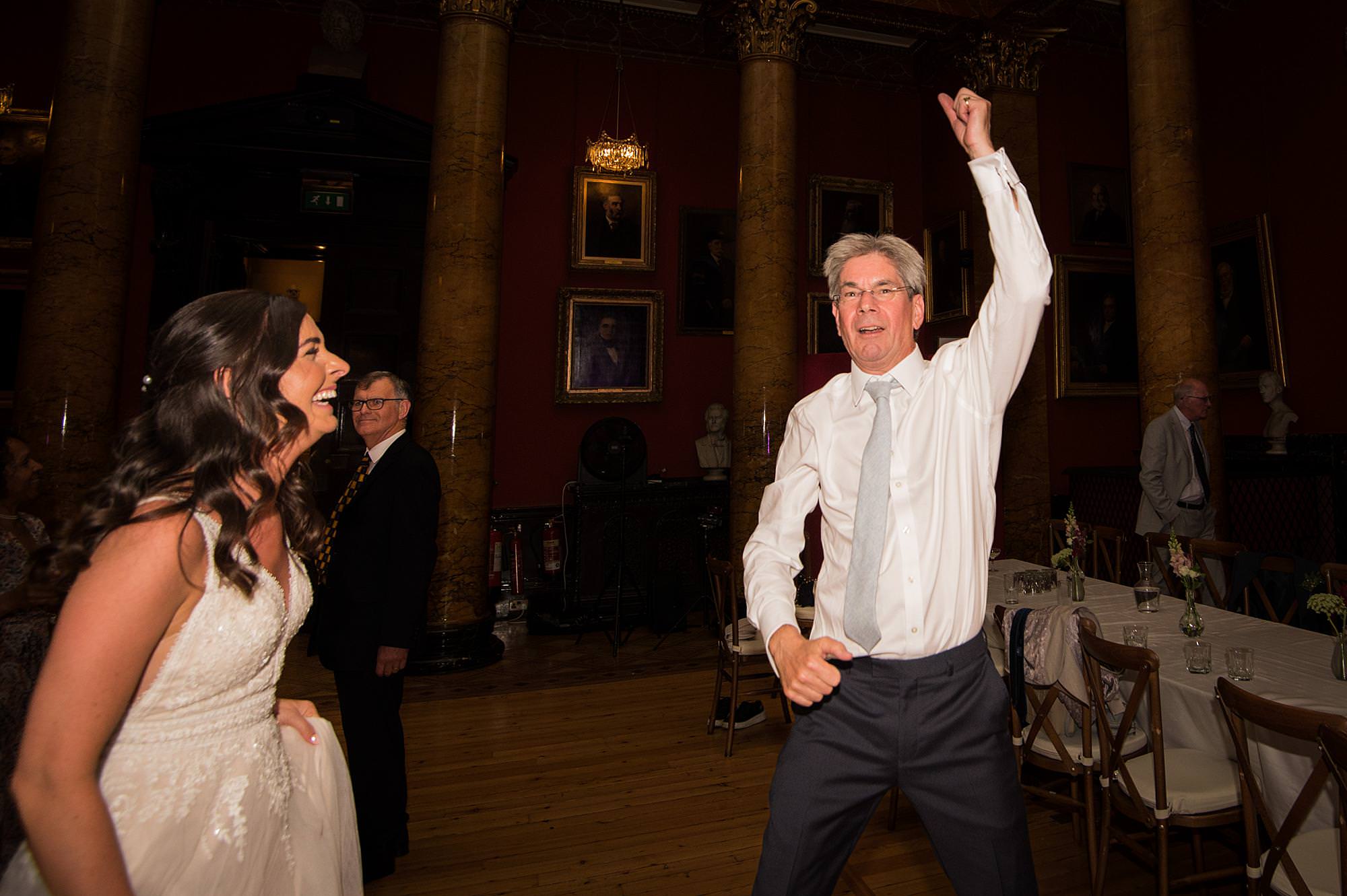 man dancing with arm up with the bride