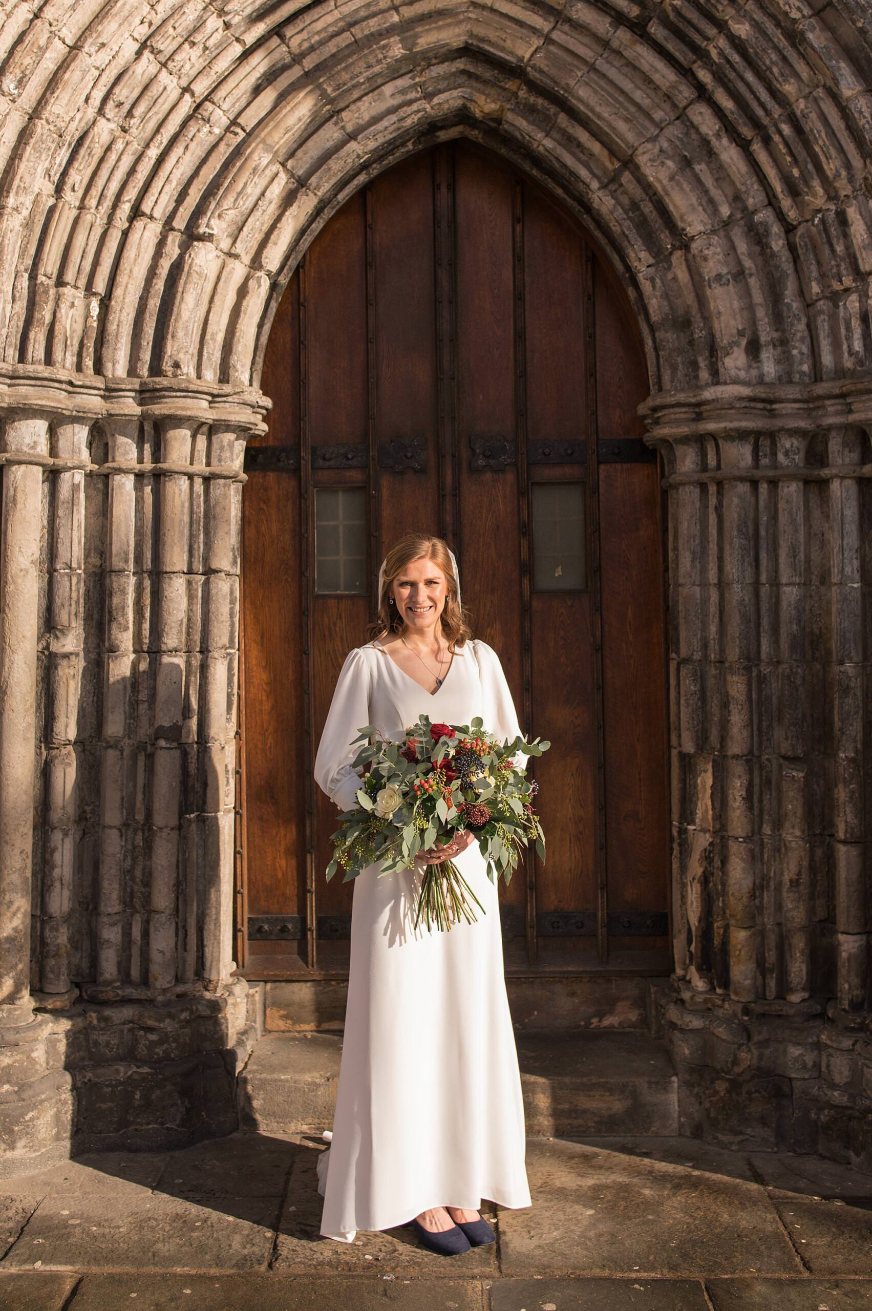 Bride stands outside paisley abbey front door