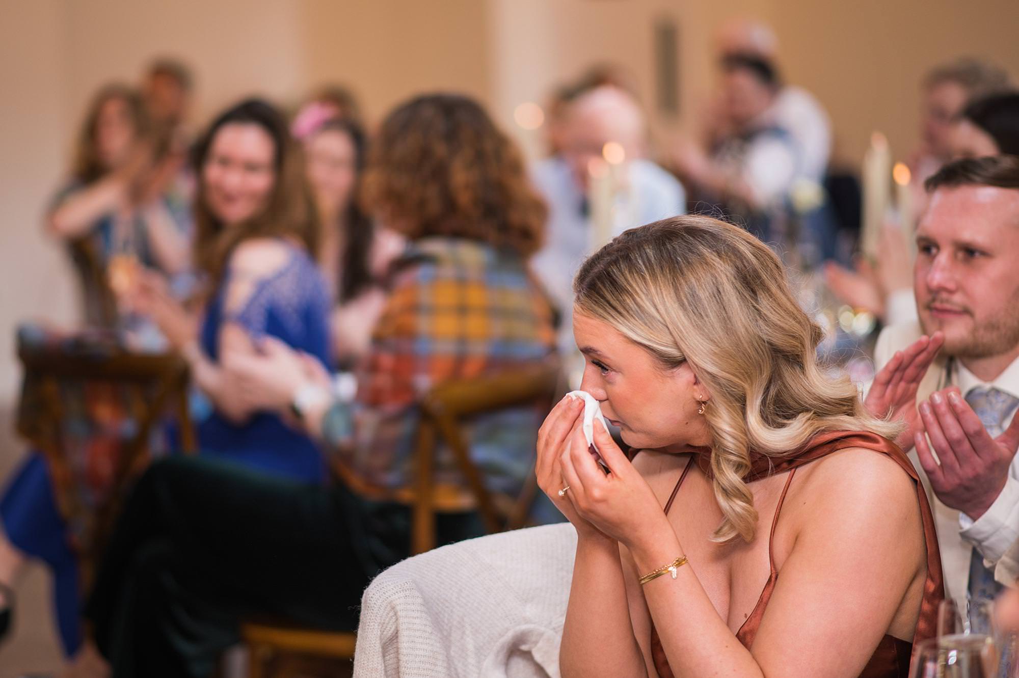 woman holds a tissue to her eye